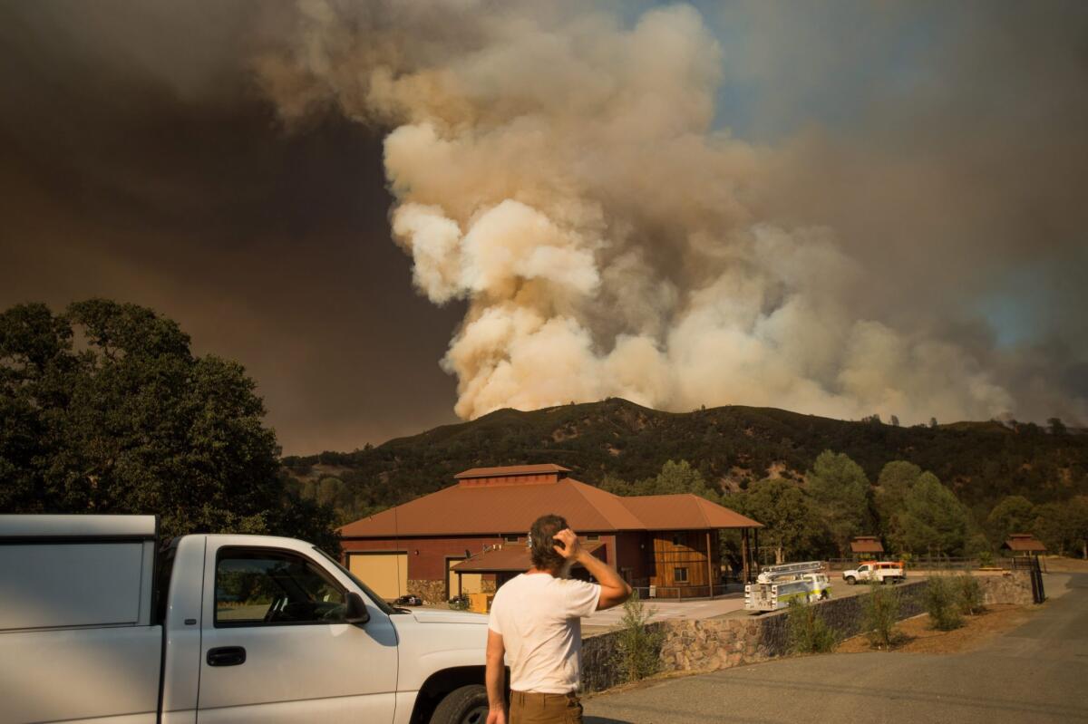Plumes of smoke rise from the Rocky fire after it jumped Highway 20 near Clearlake Oaks, Calif., on Aug. 3.