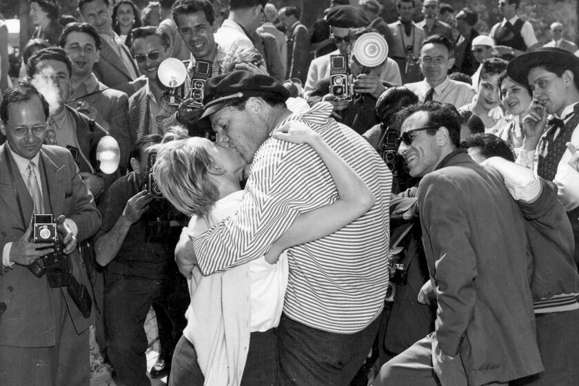 En esta foto del 28 de abril de 1955, el actor y cantante Eddie Constantine besa a su nueva esposa Helene Mussel para los fotógrafos alrededor durante el Festival Internacional de Cine de Cannes, en el sur de Francia. (AP Foto/Babout, Archivo)