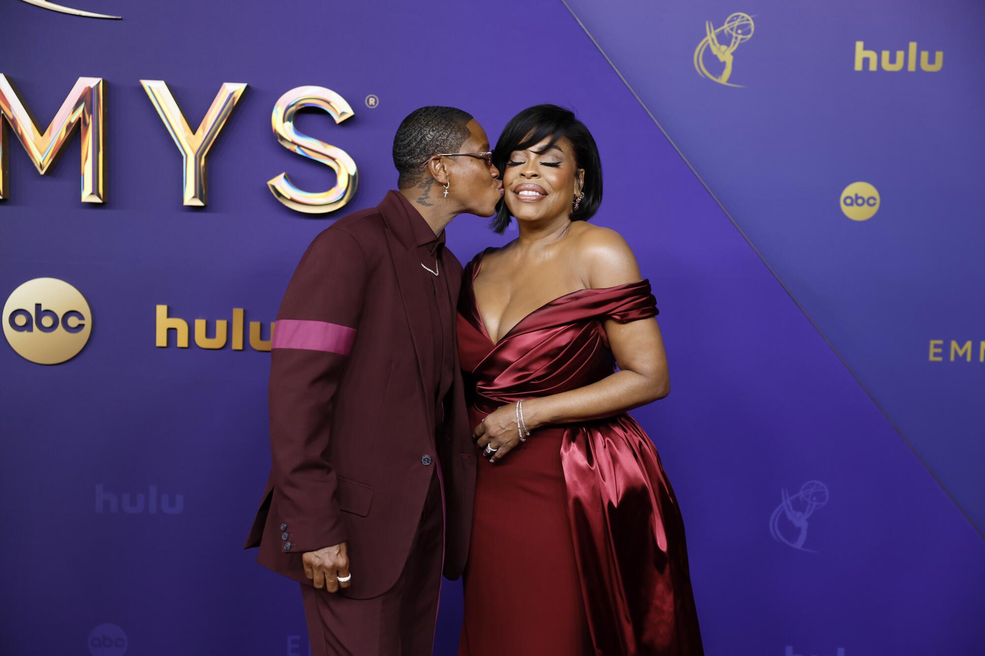 Jessica Betts kisses Niecy Nash-Betts on the red carpet.