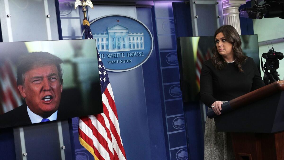 President Trump speaks via video as White House Press Secretary Sarah Huckabee Sanders listens during a daily news briefing in the White House. The new book "Fire and Fury," written by Michael Wolff, was discussed.