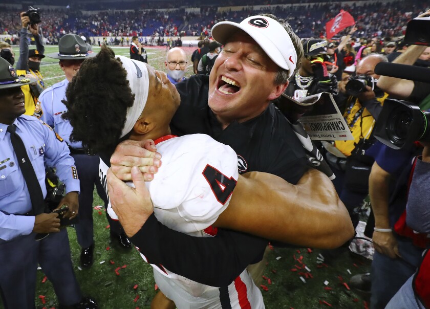 Georgia head coach Kirby Smart celebrates winning the College Football Playoff Championship game against Alabama, getting a hoist from outside linebacker Bolan Smith, early Tuesday, Jan. 11, 2022, in Indianapolis. (Curtis Compton/Atlanta Journal-Constitution via AP)