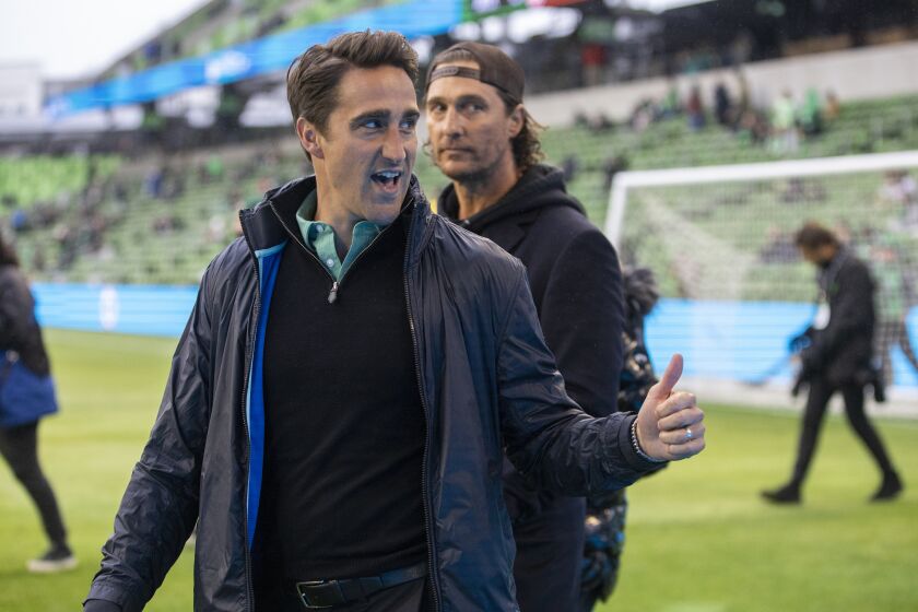 Austin FC head coach Josh Wolff, left, and actor Matthew McConaughey react to the fans.