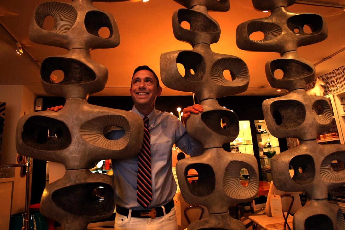 Before an It Gets Better fundraiser in his Melrose store, Jonathan Adler pauses for a portrait with his Reform Temple screen. Modular pieces of aerated concrete can be threaded onto hefty metal stands in different ways, creating singular sculpture or, when deployed in multiple, a room divider.