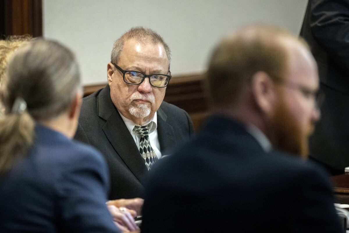 Greg McMichael. center, listens to his attorney during a motion hearing at the Glynn County Courthouse, Thursday, Nov. 4, 2021, in Brunswick, Ga. McMichael and his his son, Travis McMichael, and a neighbor, William "Roddie" Bryan, are charged with the February 2021 slaying of 25-year-old Ahmaud Arbery. (AP Photo/Stephen B. Morton, Pool)