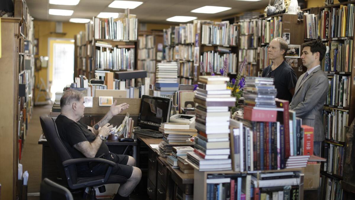 David Benesty, left, manager of Sam: Johnson's Bookshop meets with landlord Richard McNamara, center, and realtor Elliot Schwartz about the sale of the building in Mar Vista.