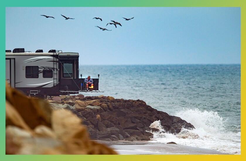 Photo of a deluxe camper van at a rocky oceanfront. 