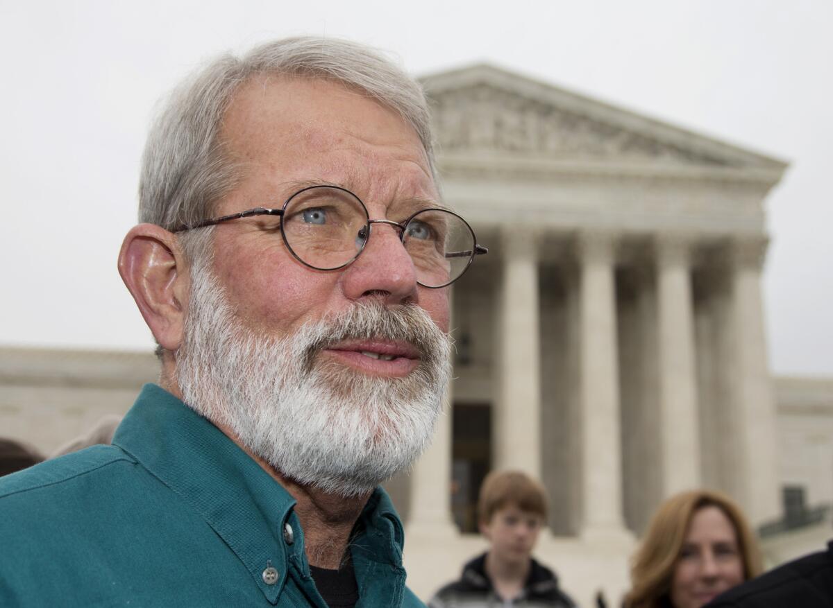 John Dennis Apel speaks to reporters outside the Supreme Court in Washington following an argument on the right to protest at a military base.
