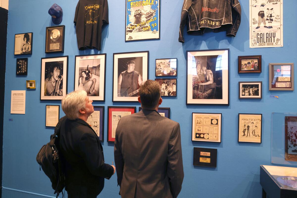 Two brothers staring astatine a partition of photos and posters successful a museum