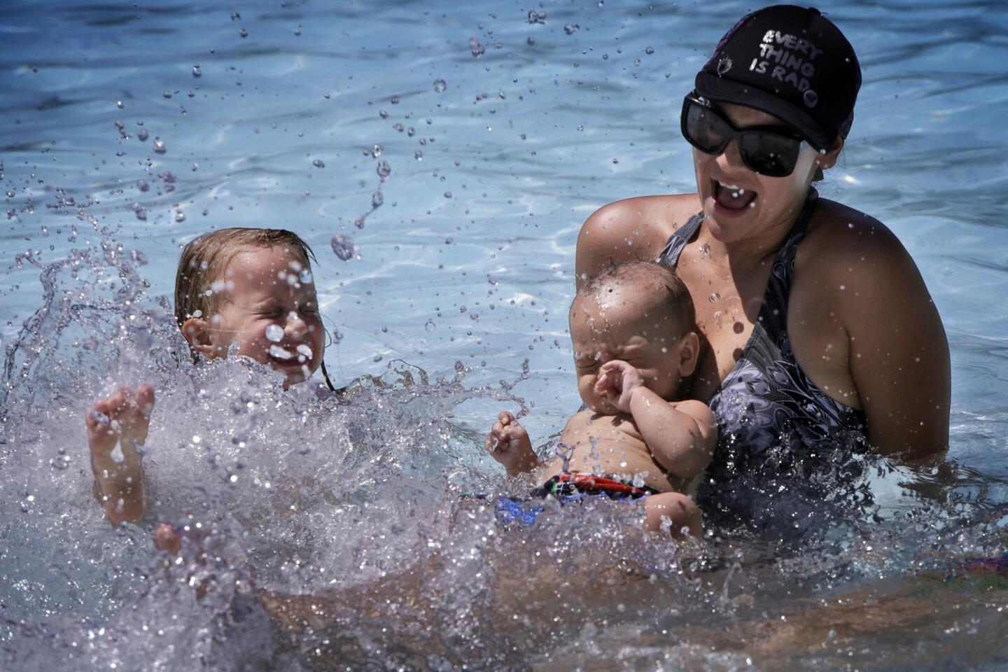Brianna Bresnahan with her 10-month-old son Luc Menor and a family friend's daughter, Haylee Weinreich,5, cool off in a pool at Cucamonga-Guasti Regional Park in Rancho Cucamonga on Thursday.