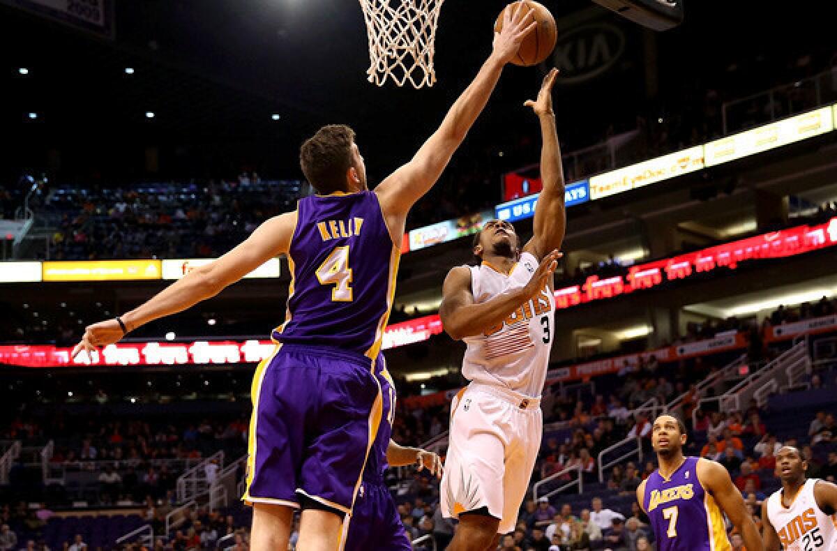 Laker forward Ryan Kelly tries to block a shot by Suns guard Ish Smith during a game Monday night in Phoenix.