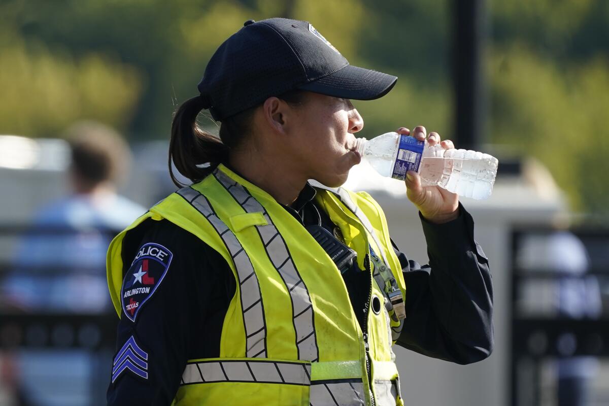 A police officer drinks a bottle of water.