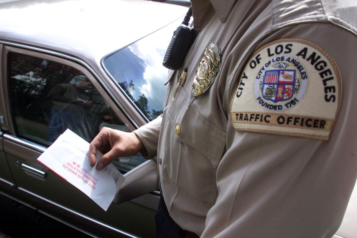 Los Angeles Traffic Officer Manny Garcia writes a parking citation for a car parked in a red zone in the Van Nuys area.