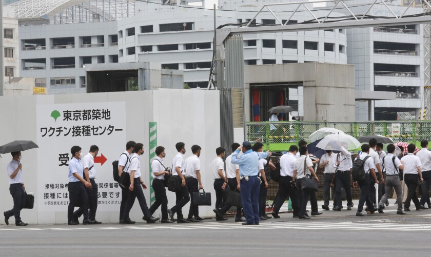 Police officers and firefighters arrive to receive the Moderna coronavirus vaccine at a former Tsukiji fish market which was turned to be a temporary mass vaccination center site set up by Tokyo metropolitan government in Tokyo Wednesday, June 16, 2021. (AP Photo/Koji Sasahara)