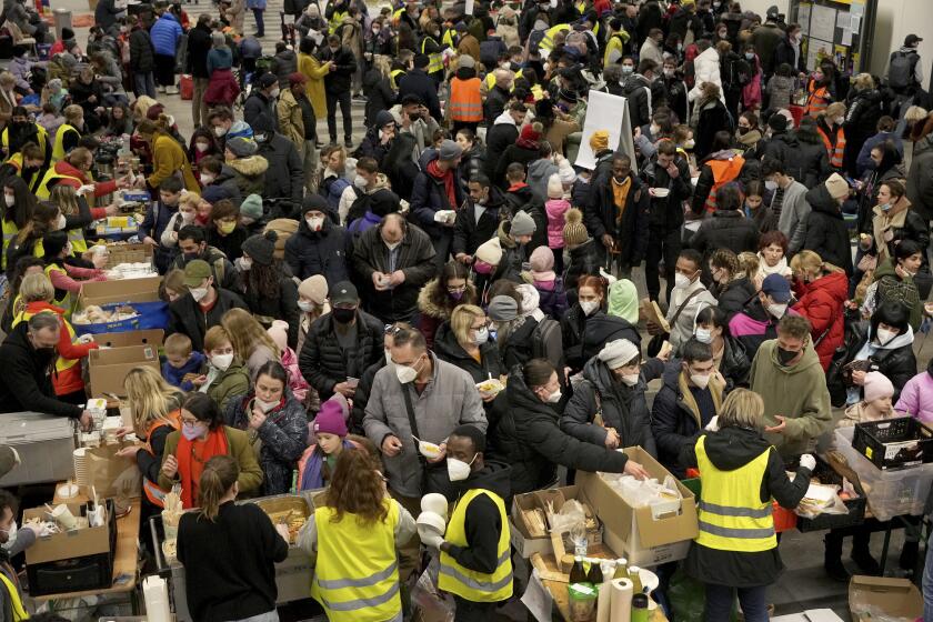 Ukrainian refugees queue for food in the welcome area after their arrival at the main train station in Berlin, Germany, Tuesday, March 8, 2022. (AP Photo/Michael Sohn)