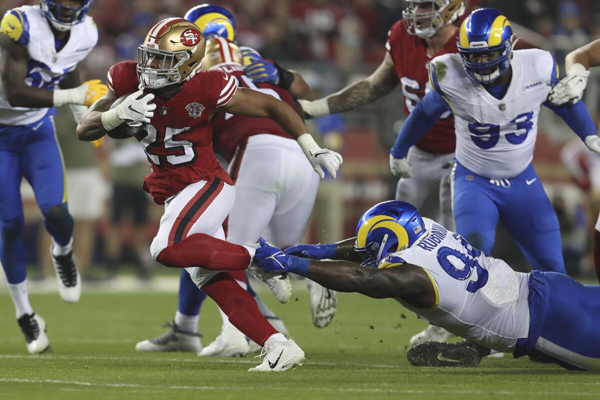 San Francisco 49ers running back Elijah Mitchell (25) runs past Rams defensive lineman A'Shawn Robinson in November.