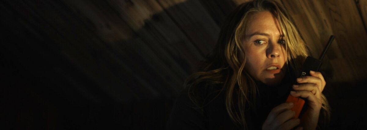 A woman clutches a walkie-talkie in the movie “Last Survivors.”