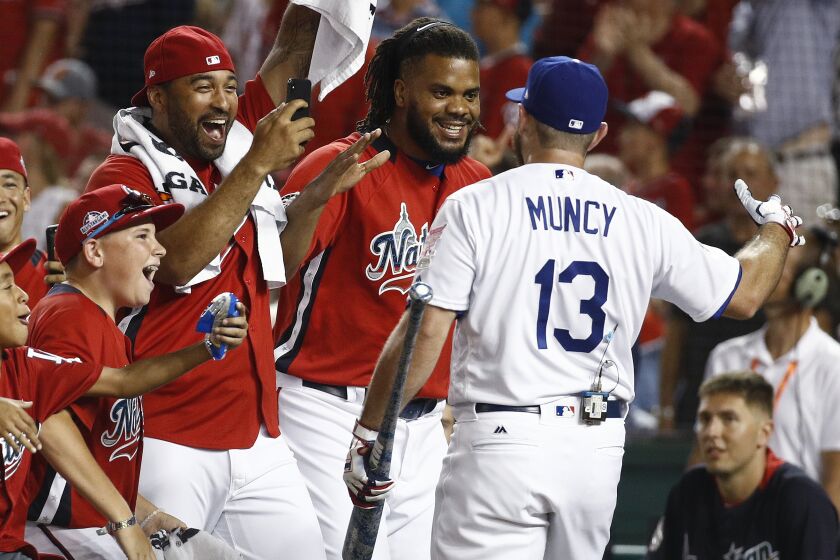 Los Angeles Dodgers Max Muncy (13) is congratulated by his National League teammates.
