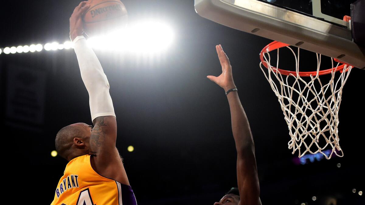 Kobe Bryant dunks over Rockets forward Clint Capela during the Lakers' 107-87 loss Thursday night.