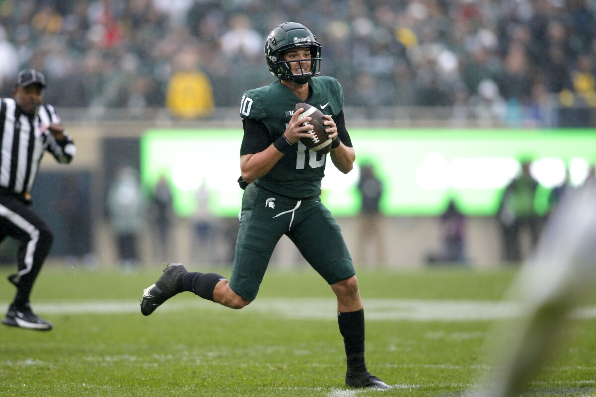 Michigan State quarterback Payton Thorne scrambles during the fourth quarter of an NCAA college football game against Michigan, Saturday, Oct. 30, 2021, in East Lansing, Mich. Michigan State won 37-33. (AP Photo/Al Goldis)