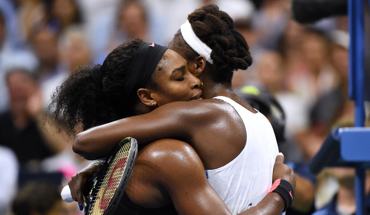 Serena Williams, left, hugs her sister Venus Williams after their U.S. Open quarterfinals women's singles match on Tuesday.