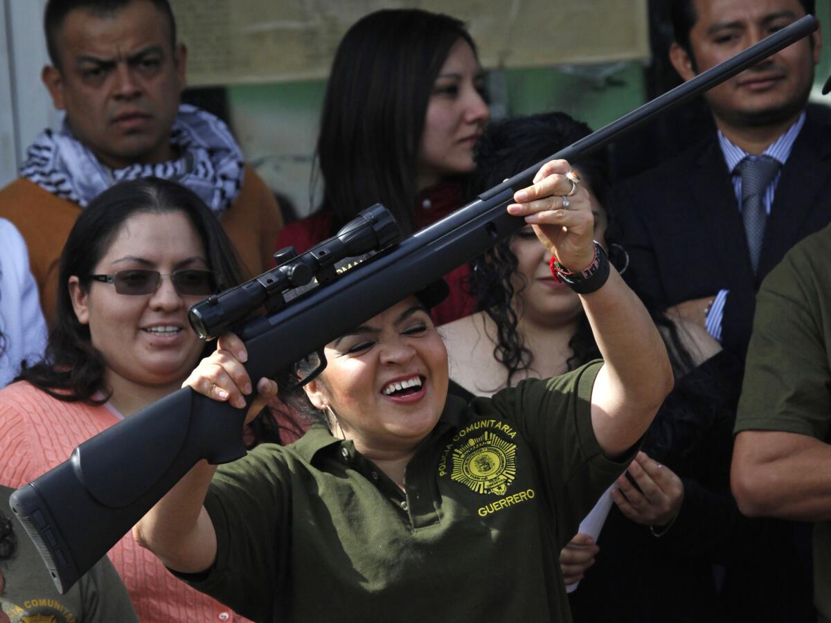 Nestora Salgado, an activist who organized community police forces, waves a rifle as she leaves a prison in Mexico City after courts threw out charges of homicide and kidnapping.