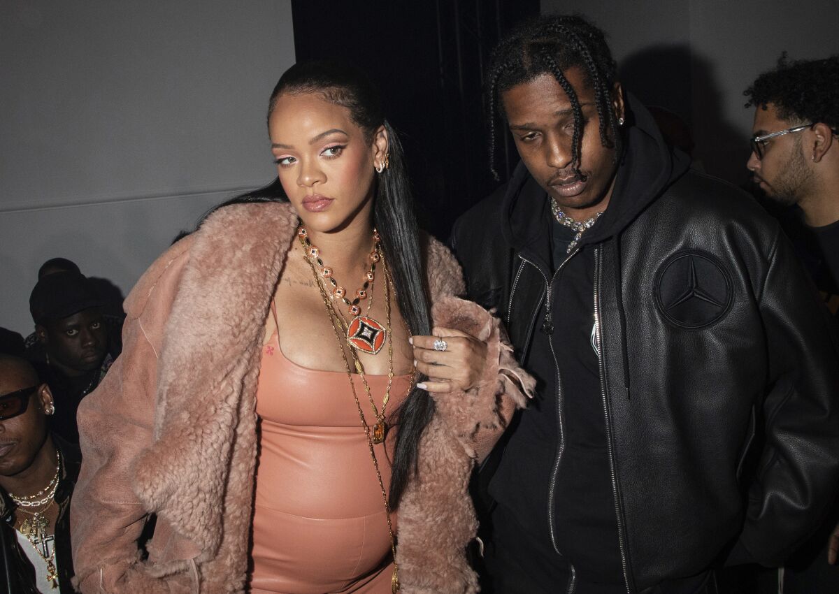 FILE - Rihanna, left, and ASAP Rocky appear at the Off-White Ready To Wear Fall/Winter 2022-2023 fashion collection, in Paris on Feb. 28, 2022. Now in her third trimester, the music star, and fashion and beauty mogul hasn't exactly been hiding under a maternity tent since she and boyfriend A$AP Rocky announced they were expecting. She's made the fashion week rounds in Milan and Paris wearing a range of couture that shows off her belly. (Photo by Vianney Le Caer/Invision/AP, File)