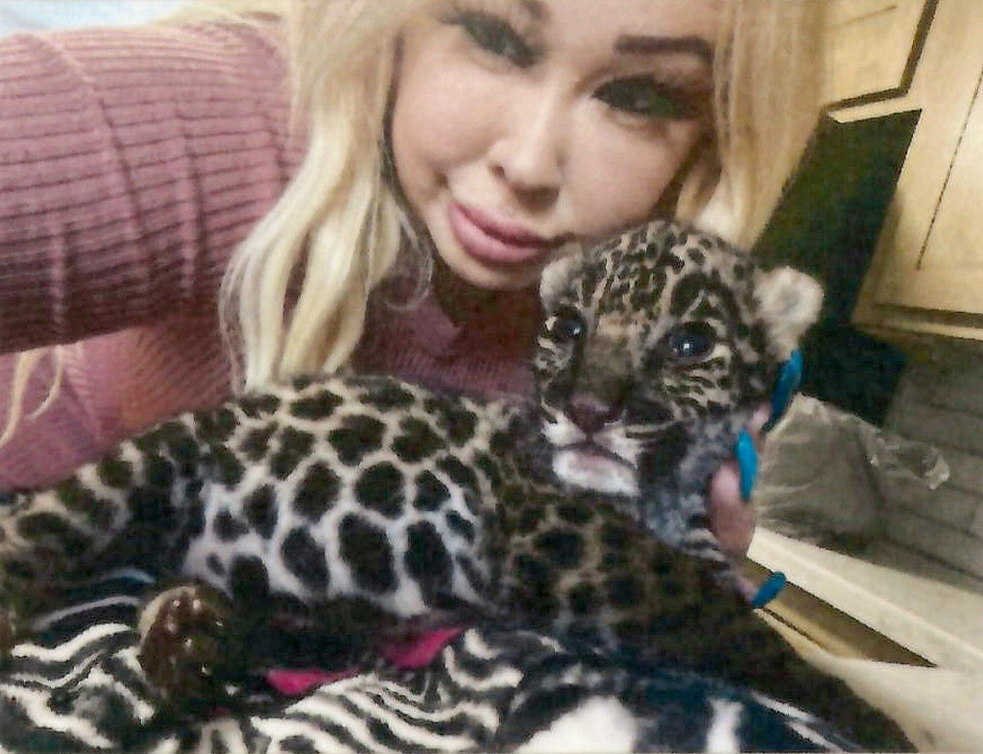 Trisha Meyer poses with the jaguar cub she named Amador.