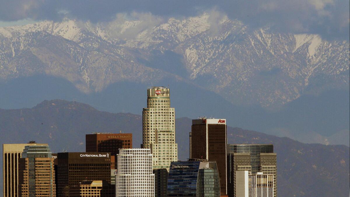 The snow-covered San Gabriel Mountains rise behind the downtown Los Angeles skyline in December 2012.