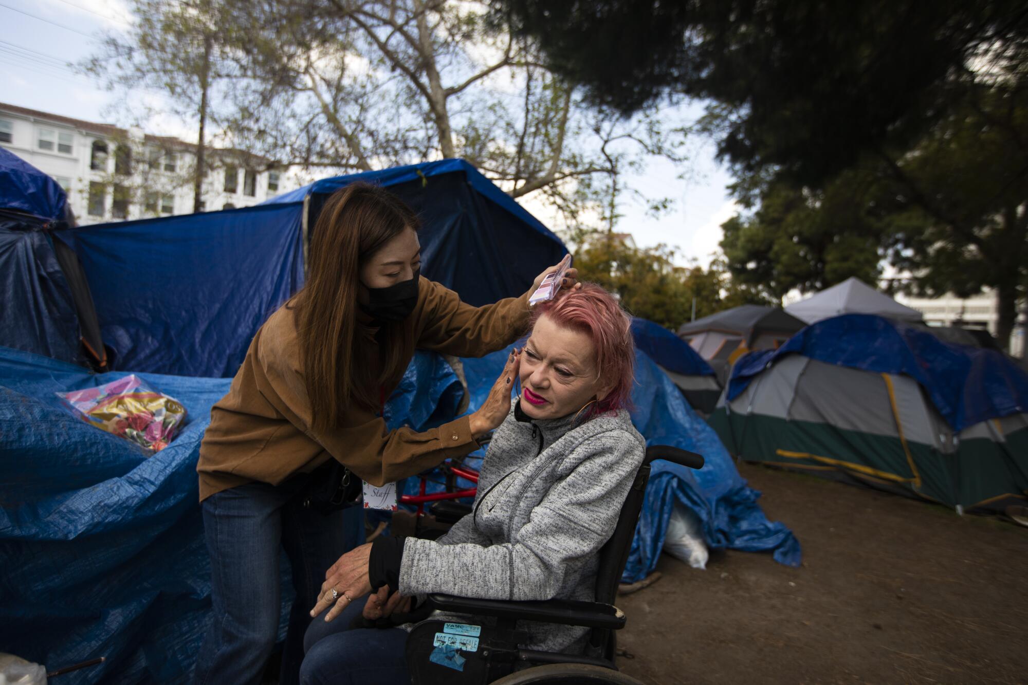 Amie Roe, with Wilderness International Church, left, helps Valerie Zeller with her makeup.