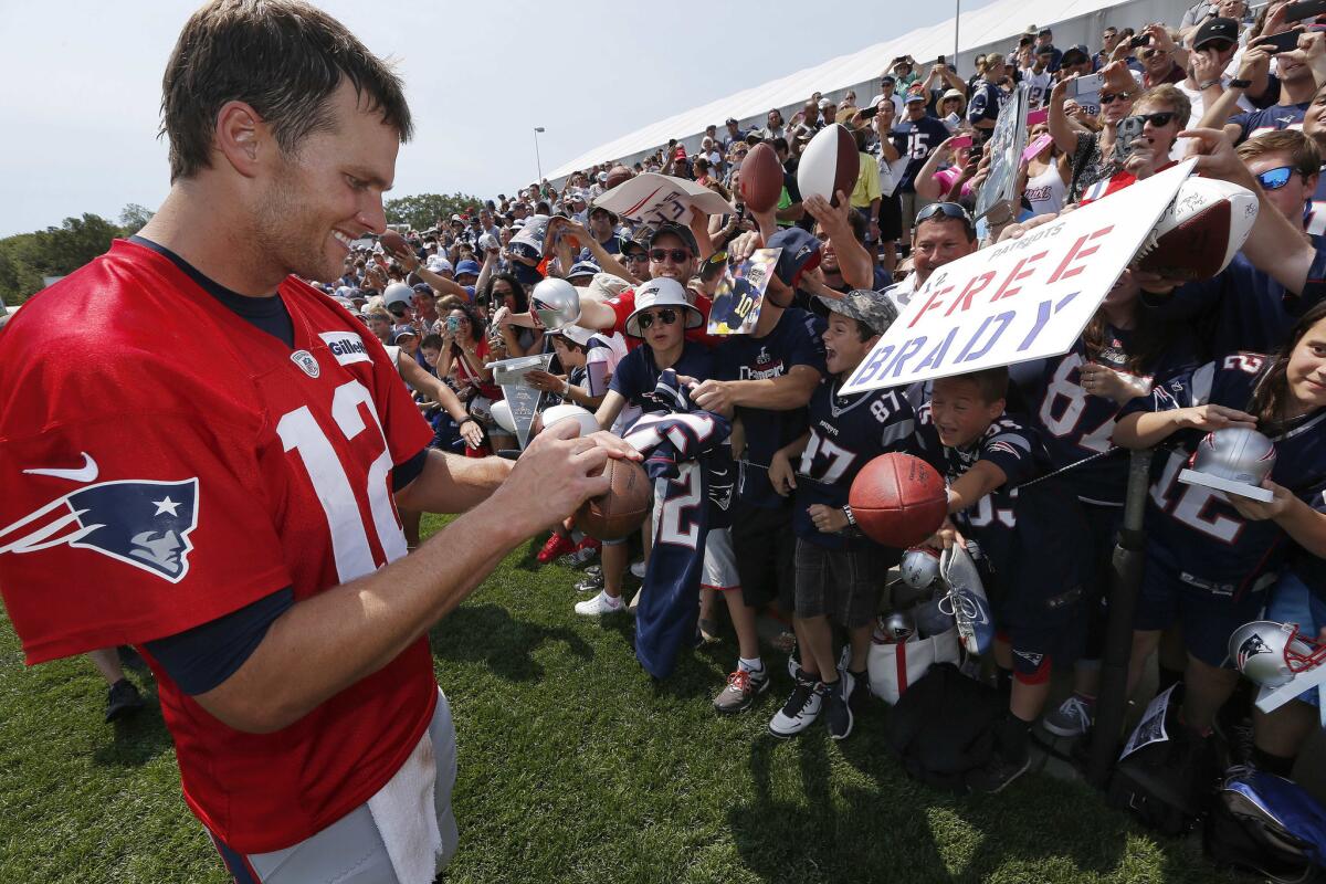 Patriots quarterback Tom Brady signs autographs during training camp in Foxborough, Mass.