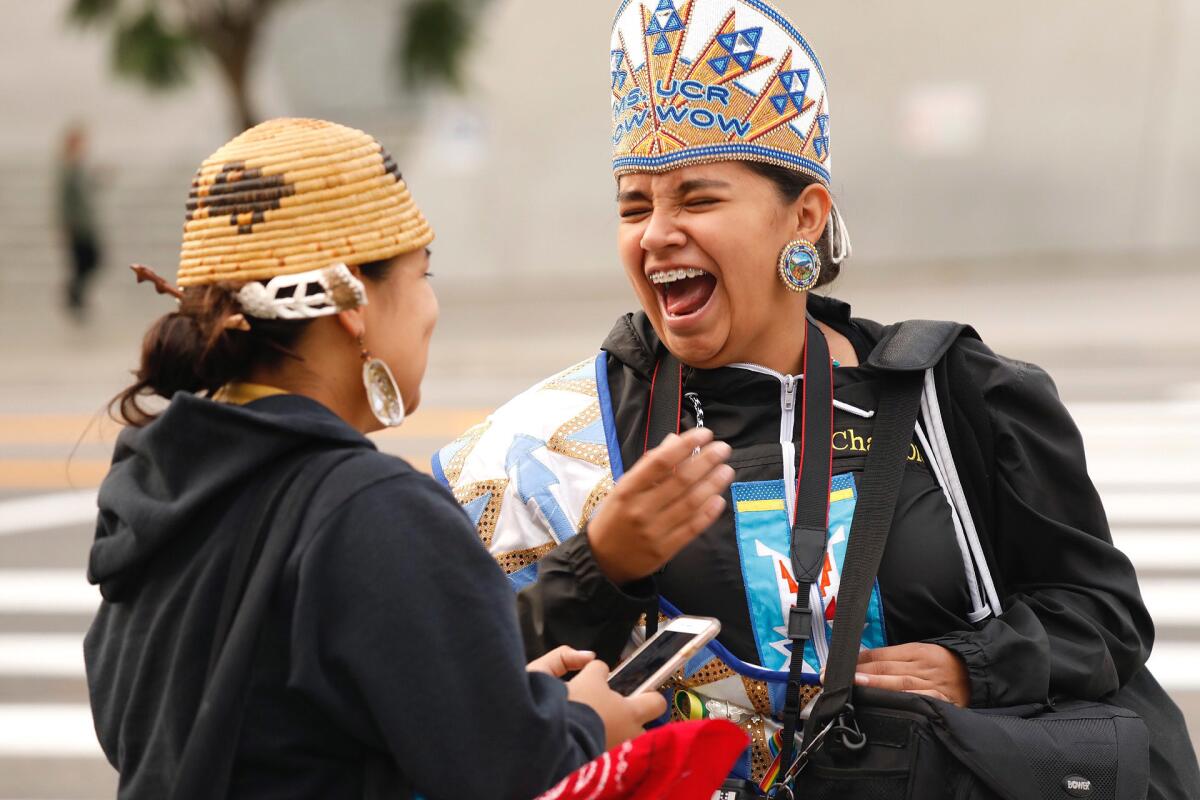 Katianna Warren, right, laughs with Miztlayolxochitl Aguilera at festivities kicking off Indigenous People Day in 2018.
