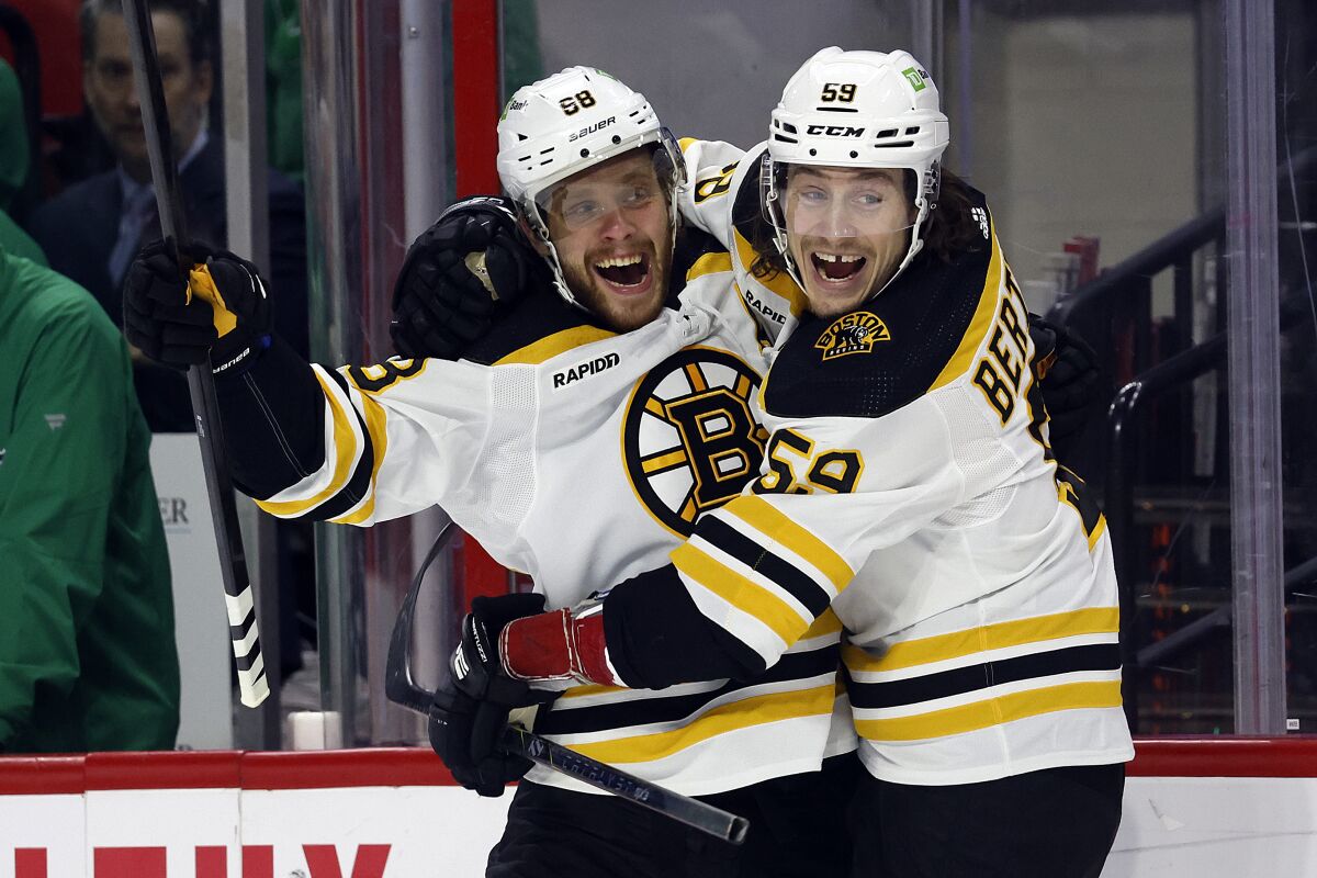 Boston Bruins' David Pastrnak (88) celebrates after his goal with teammate Tyler Bertuzzi (59) during the first period of an NHL hockey game against the Carolina Hurricanes in Raleigh, N.C., Sunday, March 26, 2023. (AP Photo/Karl B DeBlaker)