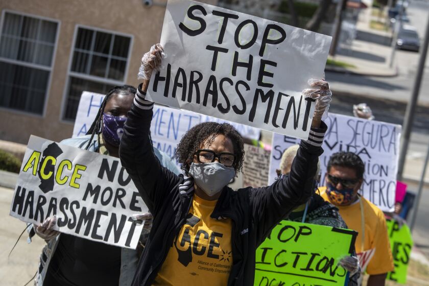 LOS ANGELES, CA - MAY 18: Jenise Dixon, center, holds a sign as she marches with neighbors and housing rights advocates who support her in her fight against harassment by the landlord of her Picfair Village neighborhood apartment on Tuesday, May 18, 2021 in Los Angeles, CA. (Brian van der Brug / Los Angeles Times)