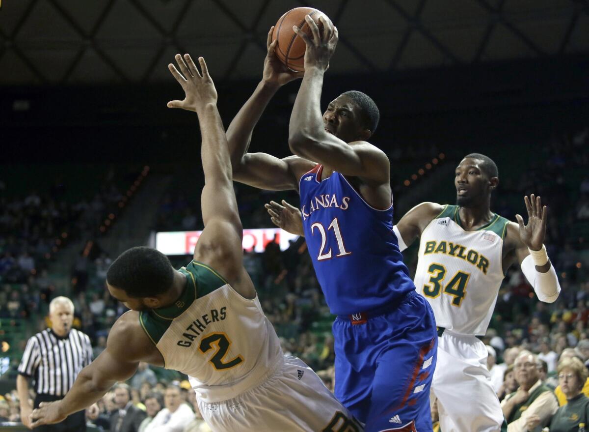 Kansas' Joel Embiid (21) blows through the Baylor defense, sending Bears forward Rico Gathers (2) to the ground as he goes up for a shot during a game on Feb. 4.