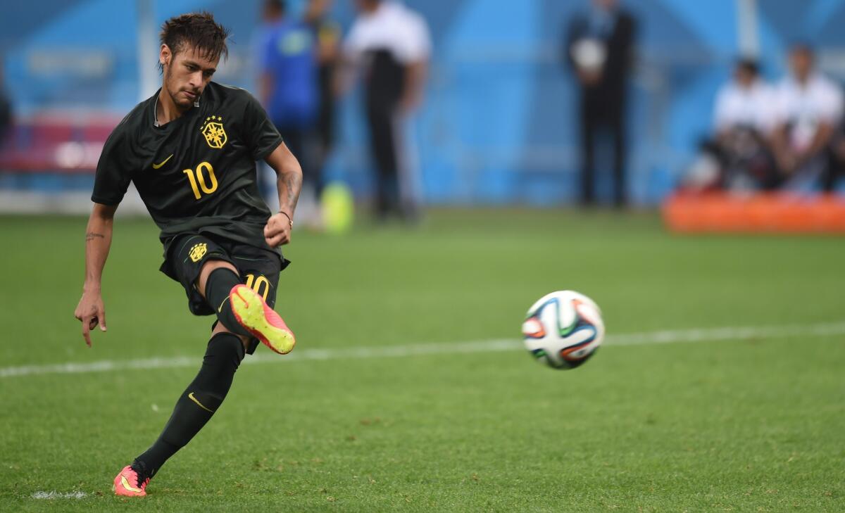 Brazil's Neymar kicks a ball during a training session of the Brazilian team at the Corinthians Arena in Sao Paulo.