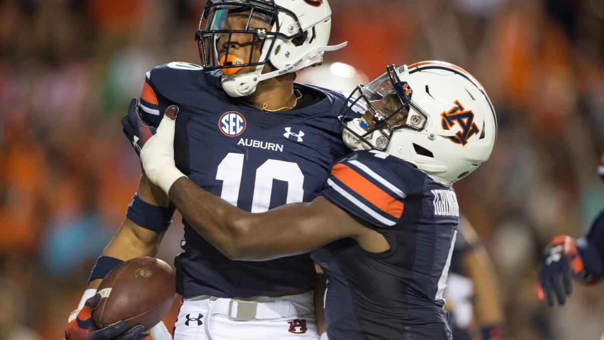 Auburn running back Devan Barrett (10) celebrates with wide receiver Noah Igbinoghene (4) after scoring a touchdown against the Alabama State in the second quarter on Sept. 8 in Auburn, Ala.