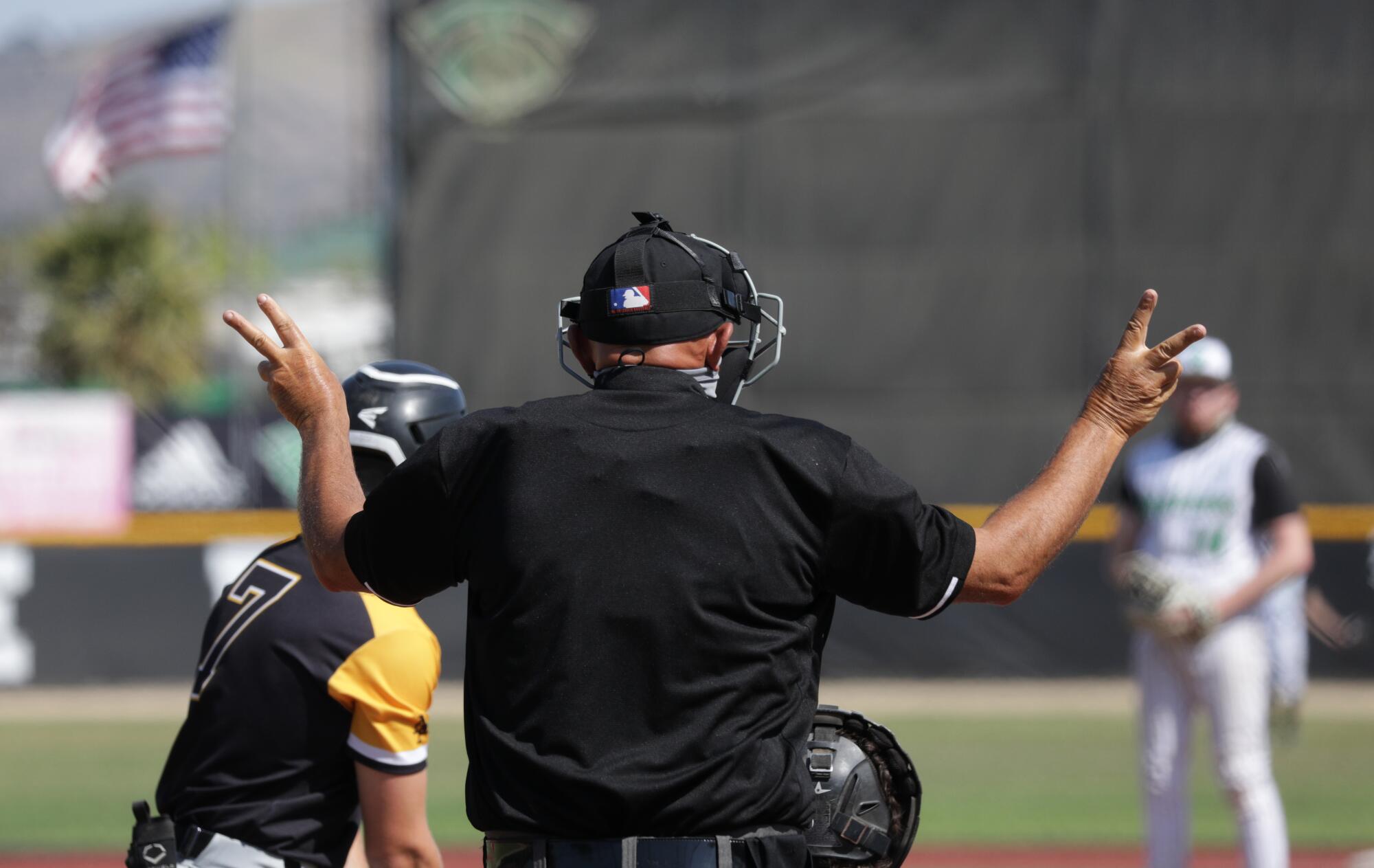 Plate umpire Jeff Sill shows a 2-2 count during an at-bat.