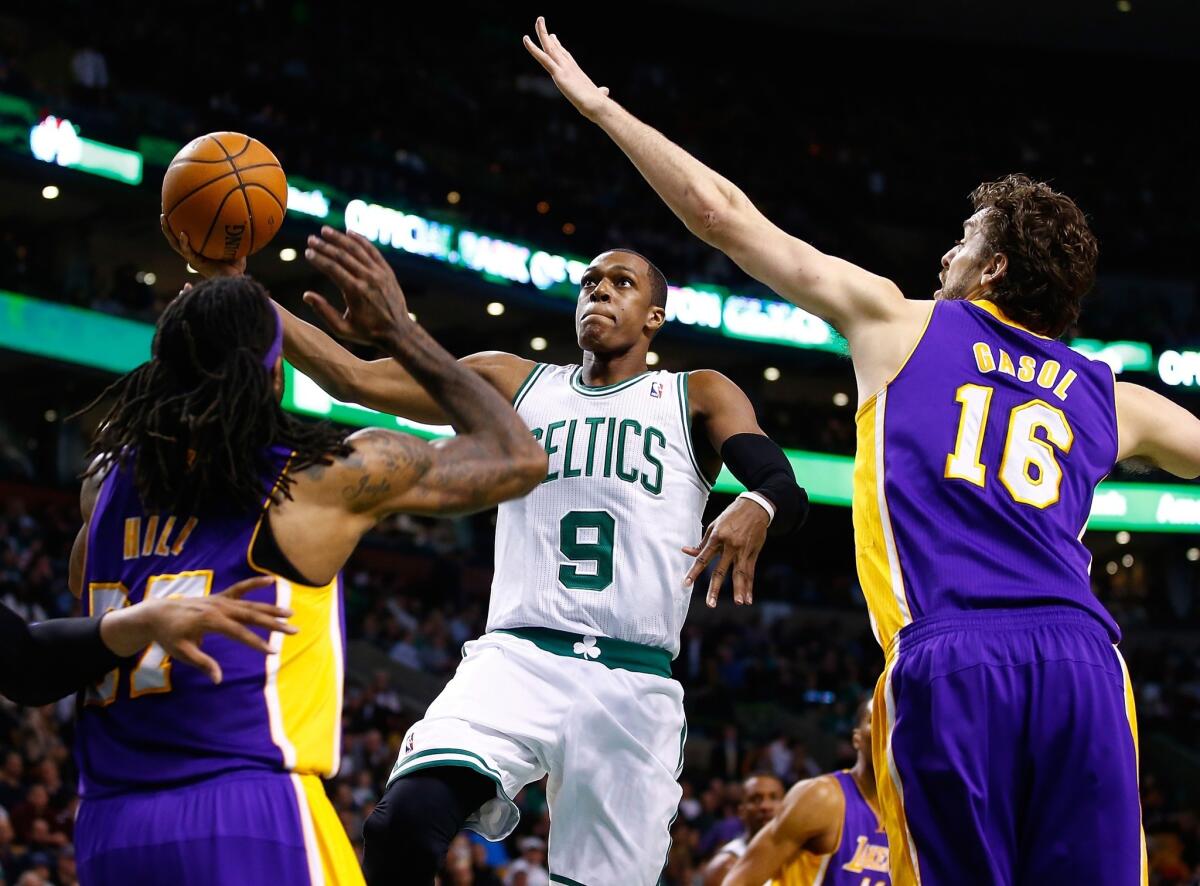 Celtics point guard Rajon Rondo takes the ball to the basket against Lakers big men Pau Gasol and Jordan Hill during a game earlier this season. Rondo and Celtics are in the draft lottery hunt with the Lakers.