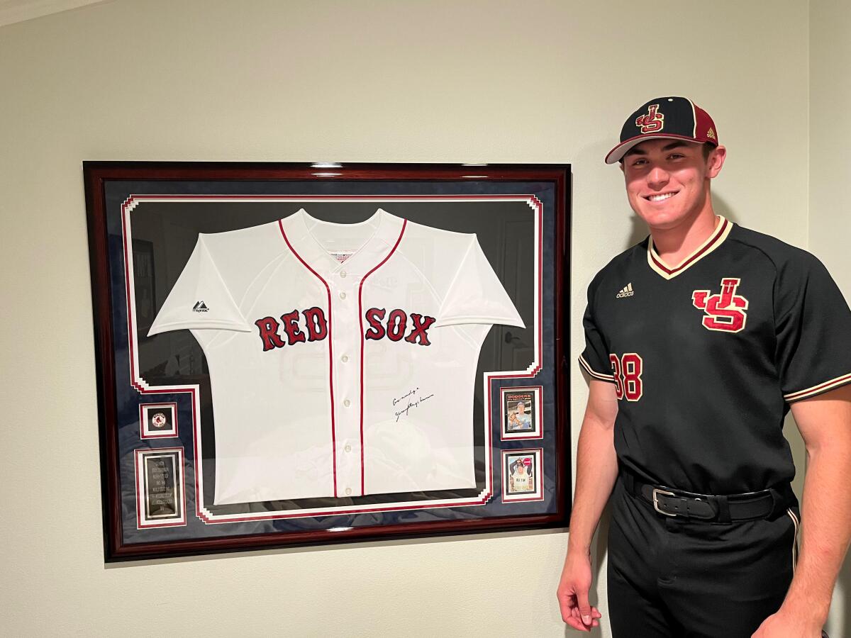 JSerra first baseman Dominic Smaldino poses next to uniform of his grandfather, Jerry Stephenson.