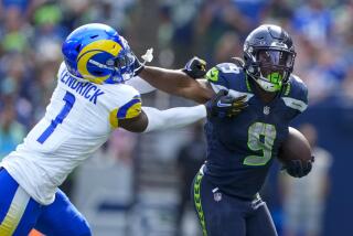  Seahawks running back Kenneth Walker III runs around Rams cornerback Derion Kendrick.