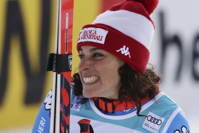 Italy's Federica Brignone, first placed, celebrates on the podium of an alpine ski, women's World Cup super-G in St. Moritz, Switzerland, Sunday, Dec. 12, 2021. (AP Photo/Marco Trovati)