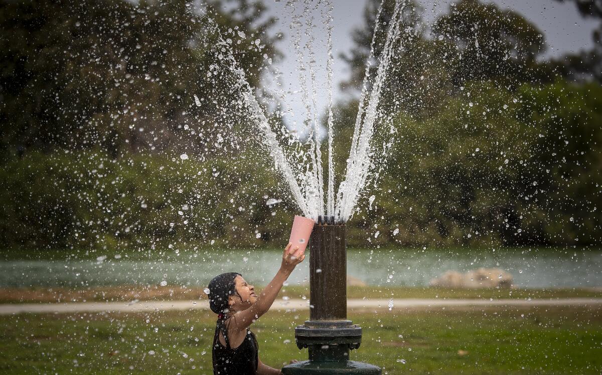 Spraying water rains down on Laura Martinez, 8, at Mile Square Park in Fountain Valley.