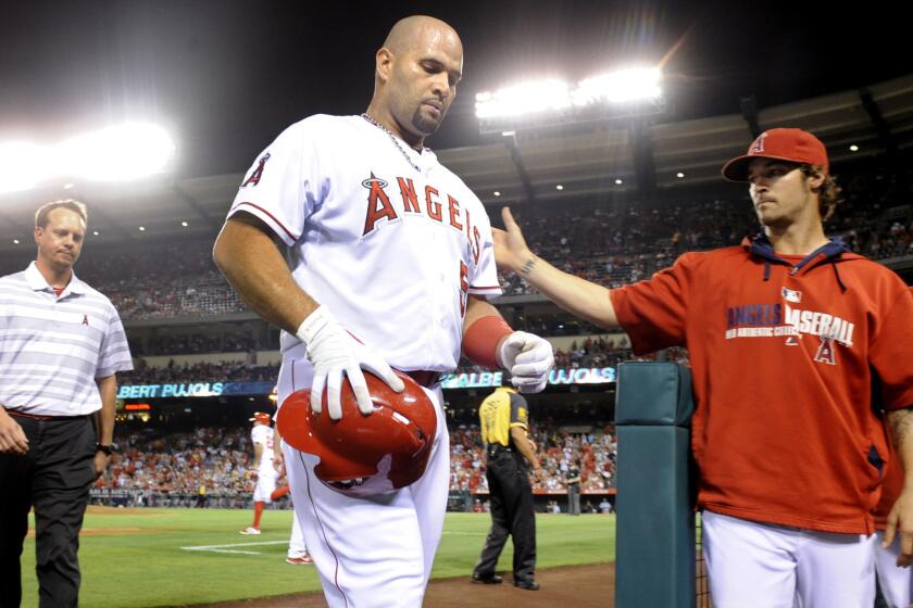 Angels first baseman Albert Pujols walks off the field after suffering a cramp in his left leg during Monday's game against the Seattle Mariners.