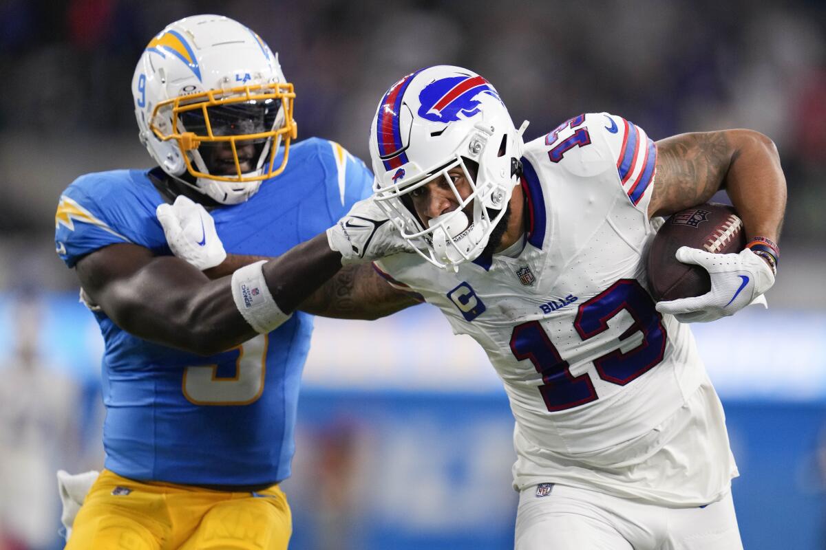 Buffalo Bills wide receiver Gabe Davis, right, fends off Chargers linebacker Kenneth Murray Jr. to score.