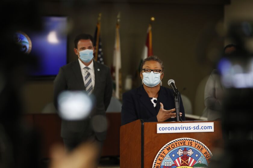 San Diego, CA - SEPT 27: Dr. Wilma Wooten speaks as San Diego County Supervisor Nathan Fletcher looks on at a news conference about Pfizer COVID-19 vaccine boosters, which are available and recommend to all eligible residents on Monday, Sept. 27, 2021 in Dana Point, CA. (K.C. Alfred / The San Diego Union-Tribune)