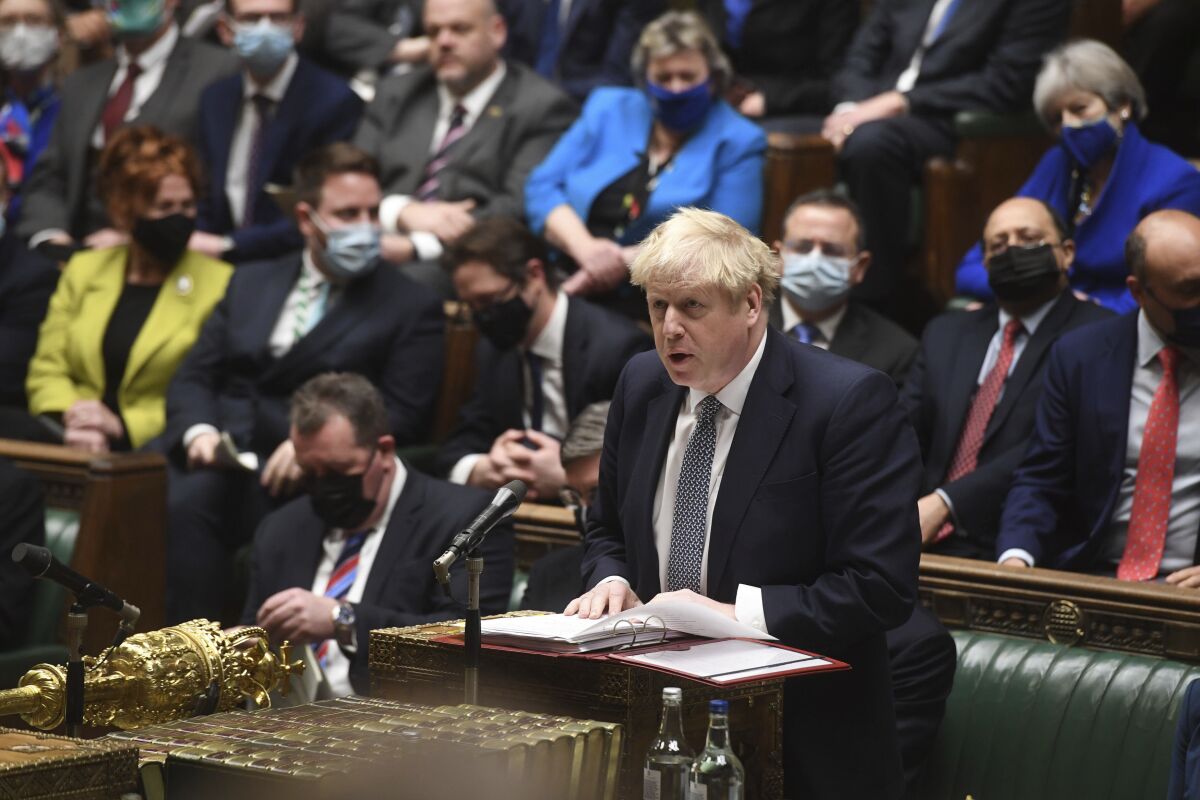 In this photo provided by UK Parliament, Britain's Prime Minister Boris Johnson speaks during Prime Minister's Questions in the House of Commons, in London, Wednesday, Jan. 12, 2022. Johnson has apologized for attending a garden party during Britain’s first coronavirus lockdown, but brushed aside opposition demands that he resign for breaching the rules his own government had imposed on the nation. The apology Wednesday stopped short of admitting wrongdoing. It was Johnson’s attempt to assuage a tide of anger from the public and politicians after repeated accusations he and his staff flouted pandemic restrictions by socializing when it was banned. (UK Parliament/Jessica Taylor via AP)