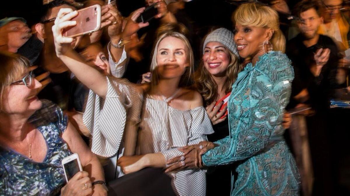 Actress and musician Mary J. Blige takes photos with fans before hitting the red carpet of the annual Palm Springs International Film Festival Gala.