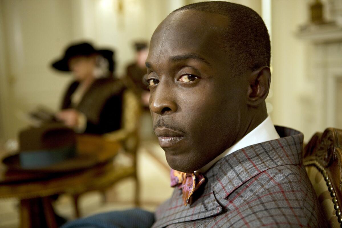 Michael K. Williams portrays Chalky White in a checked suit and colorful bowtie.