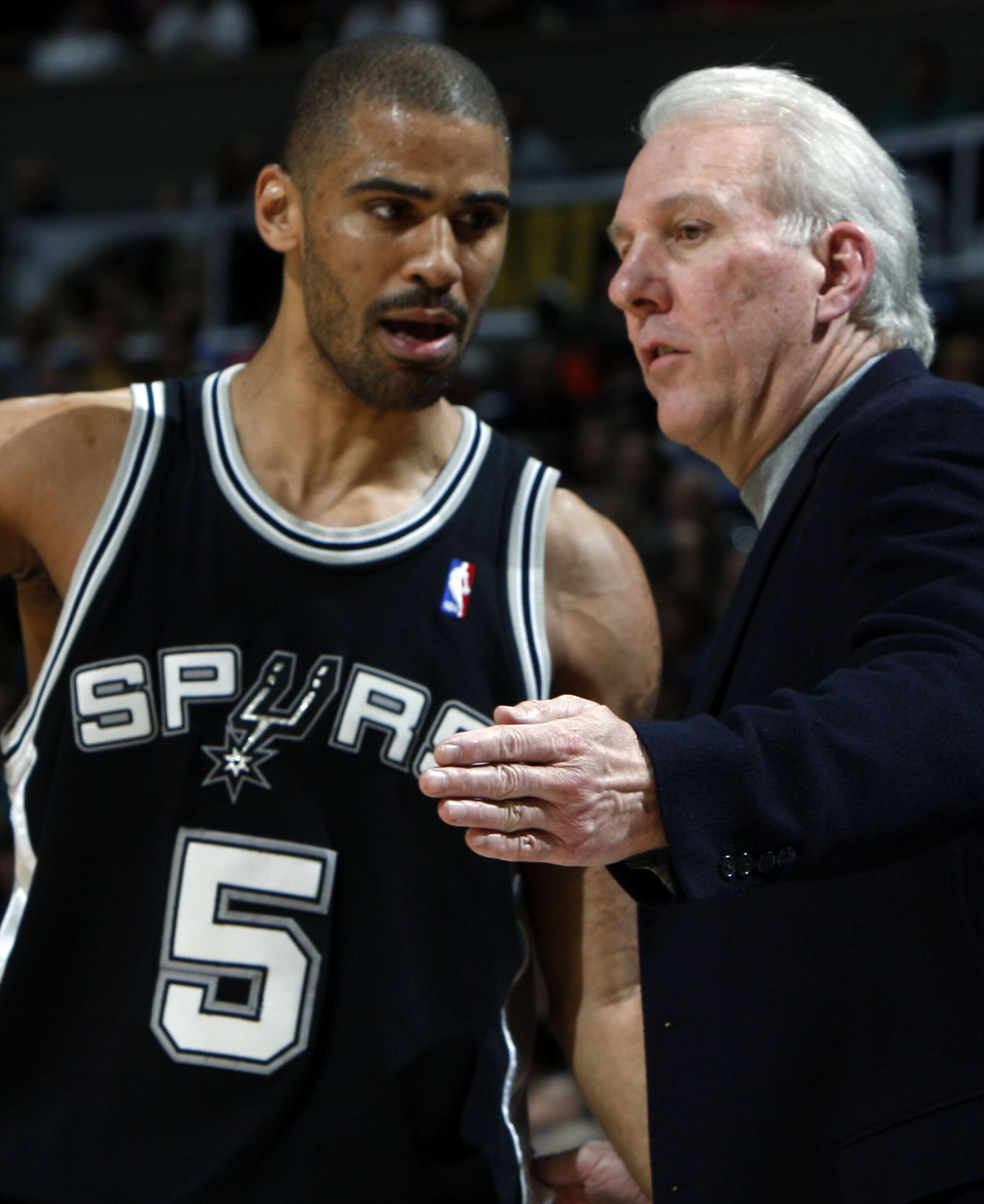 Spurs coach Gregg Popovich confers with guard Ime Udoka along the sideline during a game in 2008.
