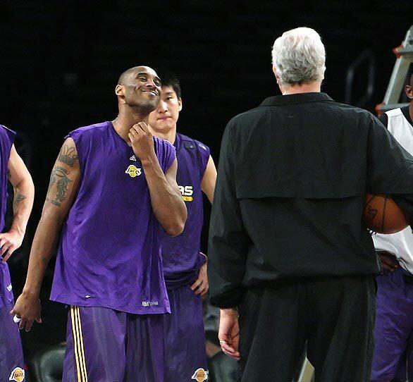 Lakers guard Kobe Bryant seems to be in a light mood as coach Phil Jackson, foreground, calls the team to practice a day before the NBA Finals at Staples Center.